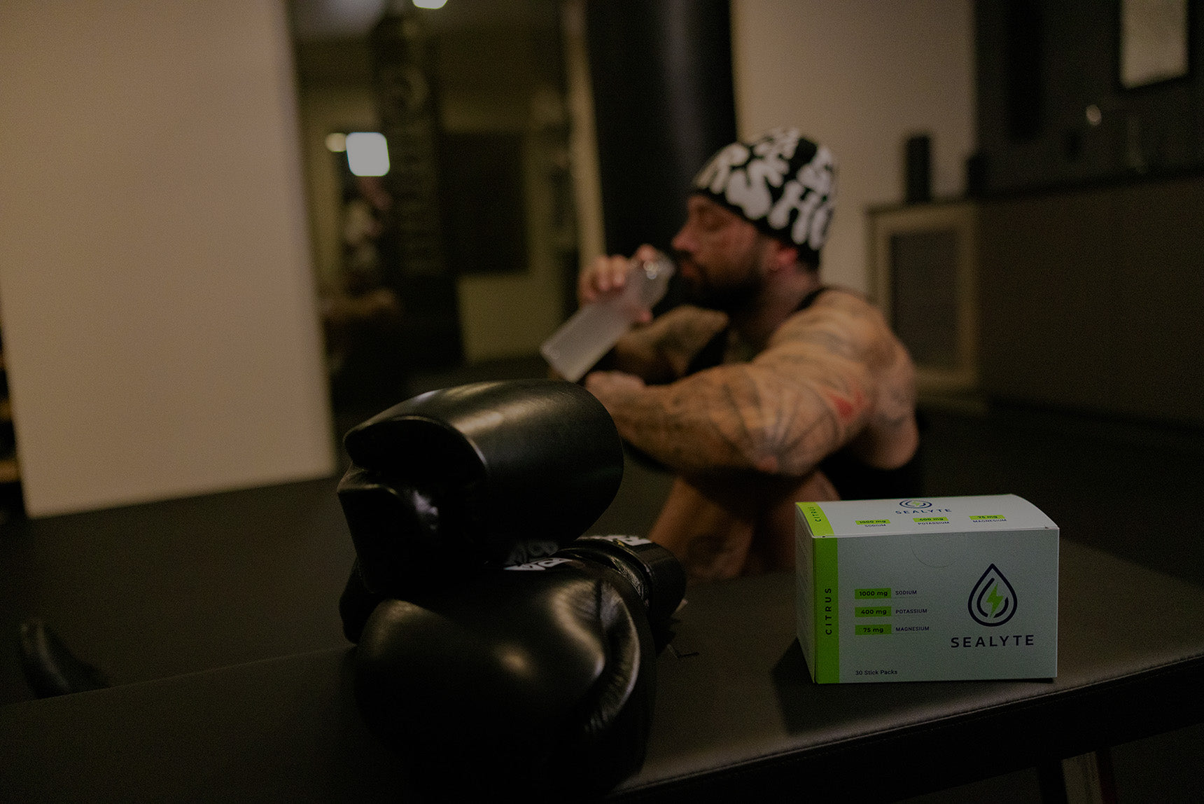 Person sitting on the floor with boxing gloves and a Sealyte package on a table.